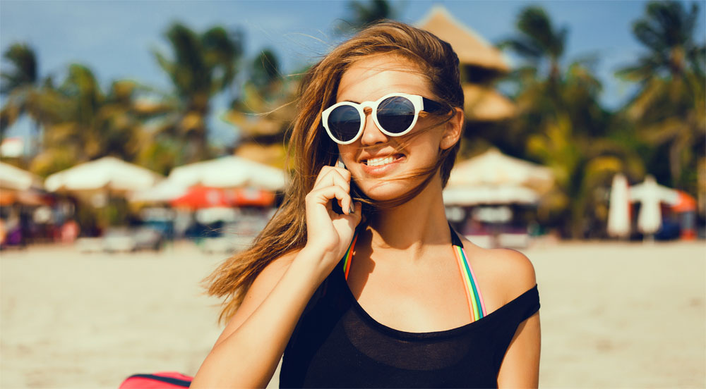 Am Strand telefonierende Frau